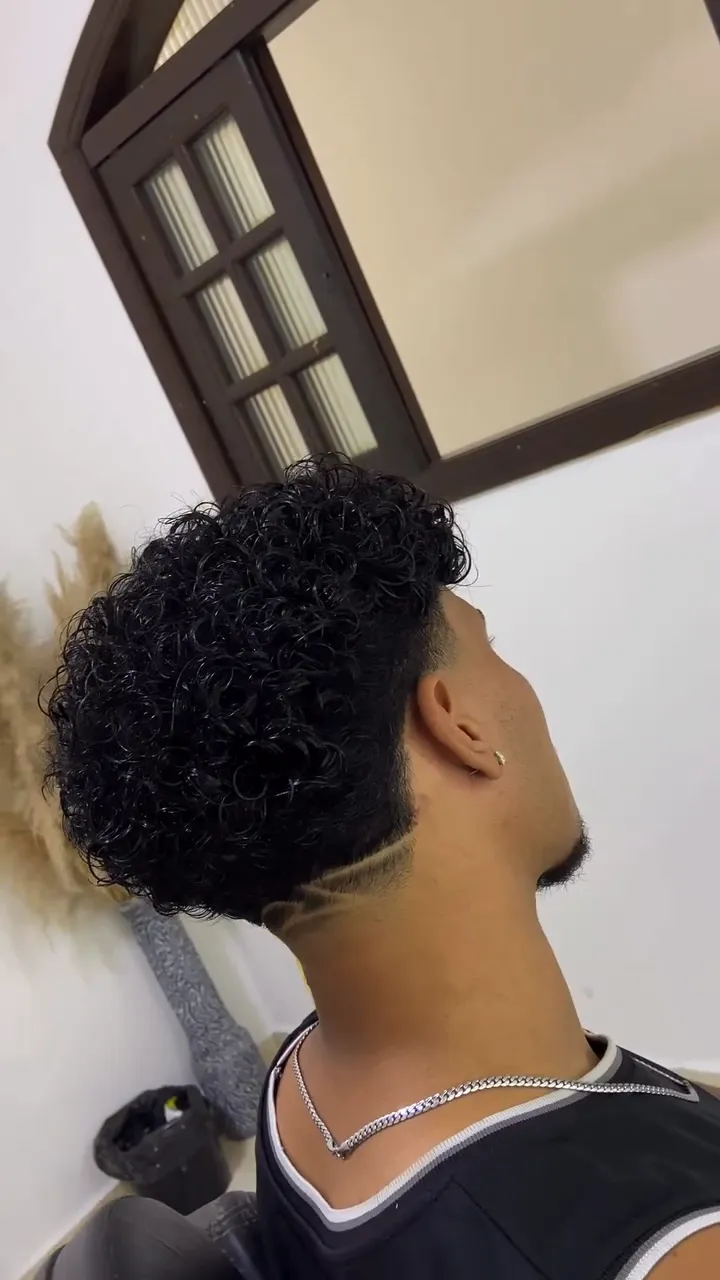 Cliente de cabelo cacheado com risco desenhado na nuca