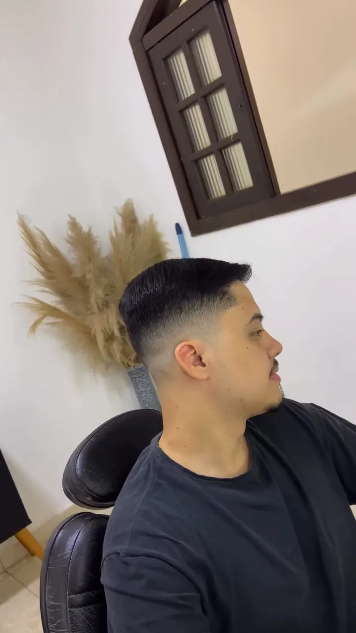 Cliente de perfil com low fade e cabelo penteado para trás