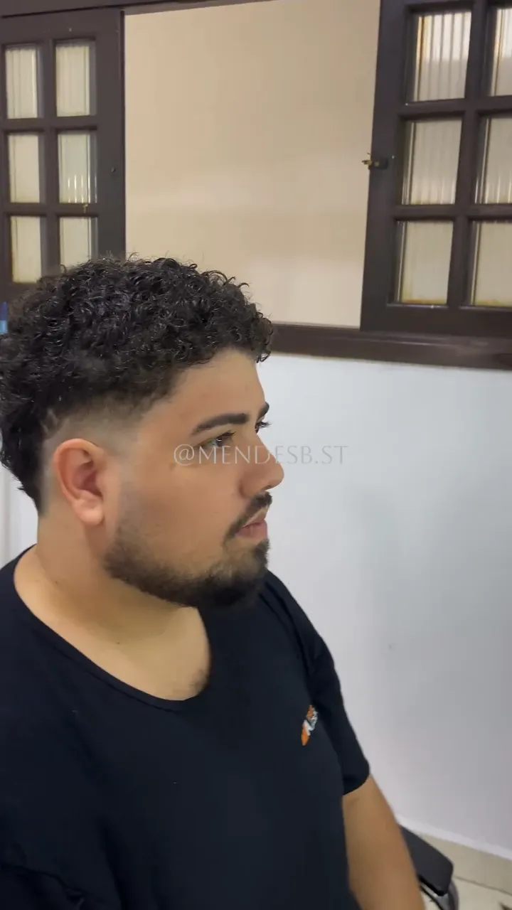 Depois: o mesmo cliente com degradê nas laterais, cachos definidos em cima e barba aparada